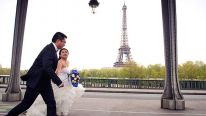 A bride and her husband walk in front of the Eiffel tower 