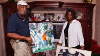 David Lucas holds a picture of his son, Al Lucas, taken during Al's time with the Carolina Panthers, as Elaine Lucas, right, holds Al's jersey that he wore with the Arena Football League's Tampa Bay Storm, Thursday, Aug. 18, 2005. Al was killed in an Aren
