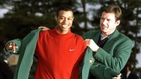 1996 US Masters winner Nick Faldo of Great Britain helps 1997 winner Tiger Woods 