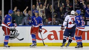 New York Rangers left wing Carl Hagelin (62), of Sweden, and right wing Ryan Callahan (24) celebrate with center Derek Stepan (21) after Stepan scored a goal as Washington Capitals left wing Alex Ovechkin (8), of Russia, skates past them in the third peri