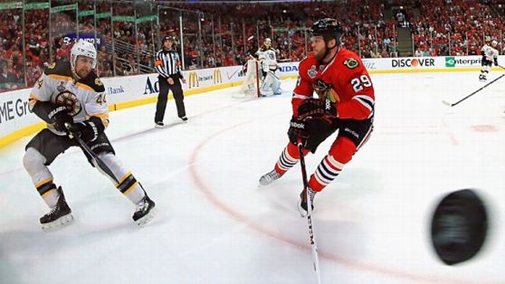 Dennis Seidenberg #44 of the Boston Bruins shoots the puck past Bryan Bickell #29 of the Chicago Blackhawks