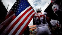 Nate Boyer #37 of the Texas Longhorns carries an American flag as the Texas Longhorns take to the field against the Oklahoma Sooners at Cotton Bowl on October 13, 2012 in Dallas, Texas.